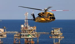 Helicóptero amarelo decolando de plataforma offshore
