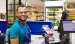 Operador de caixa trabalhando em supermercado, representando as mais de 300 oportunidades de emprego disponíveis em Campos