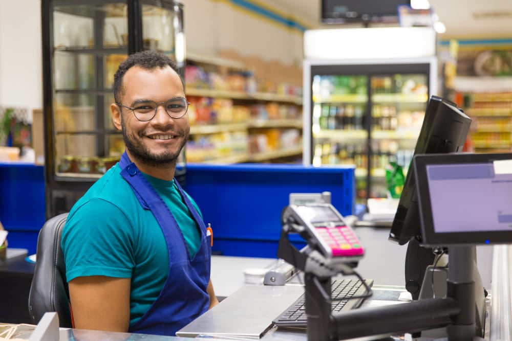 Operador de caixa trabalhando em supermercado, representando as mais de 300 oportunidades de emprego disponíveis em Campos