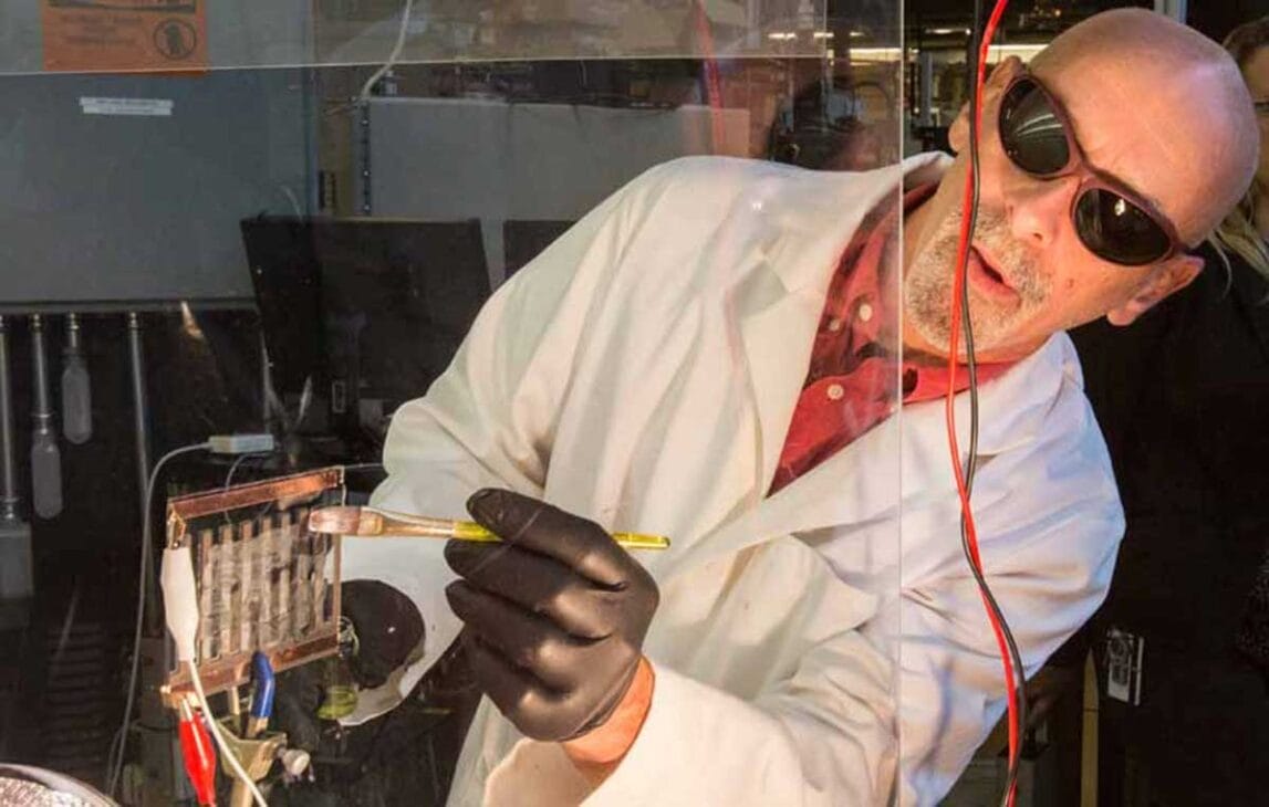 Cientista pintando uma superfície de vidro com a tinta perovskita. Fonte da imagem: nrel.gov