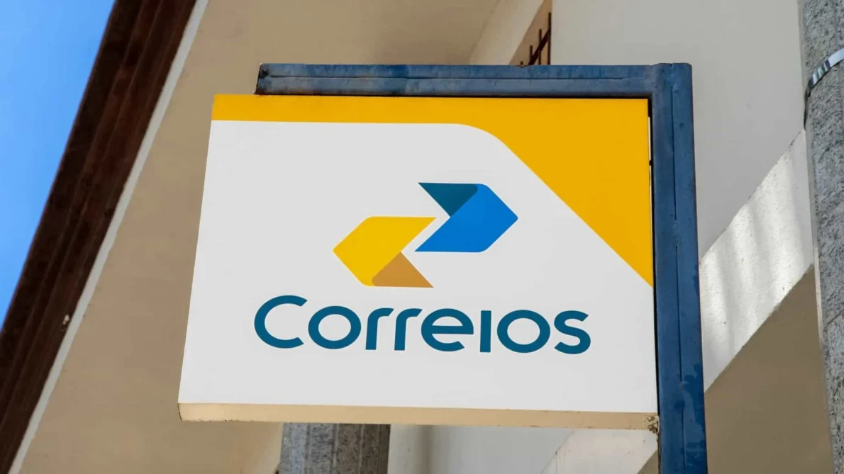 Placa publicitária da empresa Correios com logotipo em fundo branco e detalhes amarelo e azul.