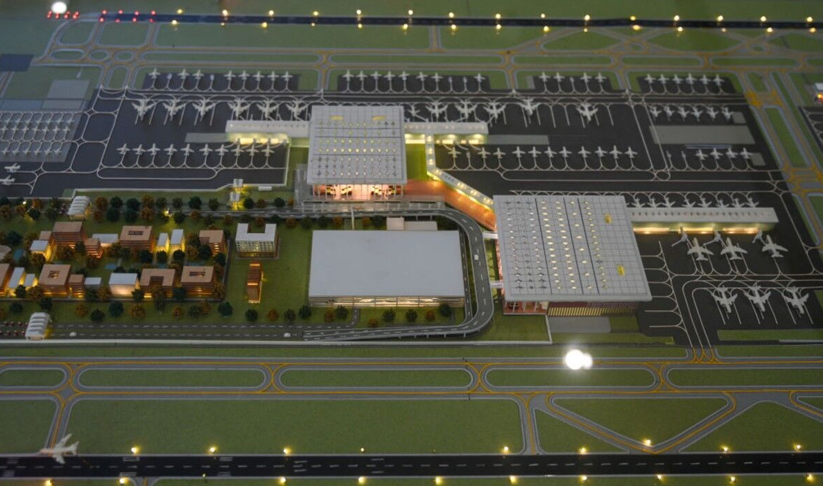 O novo aeroporto terá uma área total de 1.334 hectares, equivalente a mais de 1.800 campos de futebol. Quando estiver totalmente concluído, contará com quatro terminais e seis pistas, podendo atender 70 milhões de passageiros por ano, tornando-se o maior da Índia.