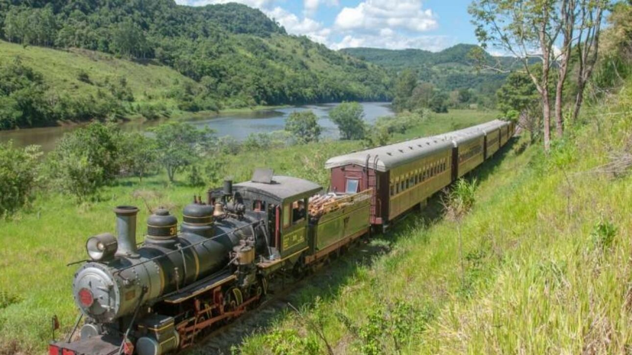 Viaje por uma ferrovia histórica em SC por menos de R$ 100, cruzando túneis e pontes com vista para a mata nativa a bordo de uma Maria Fumaça. (Imagem: site Viagens Sem Caminho)
