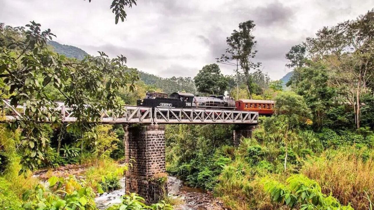 Viaje por uma ferrovia histórica em SC por menos de R$ 100, cruzando túneis e pontes com vista para a mata nativa a bordo de uma Maria Fumaça. (Imagem: site Viagens Sem Caminho)