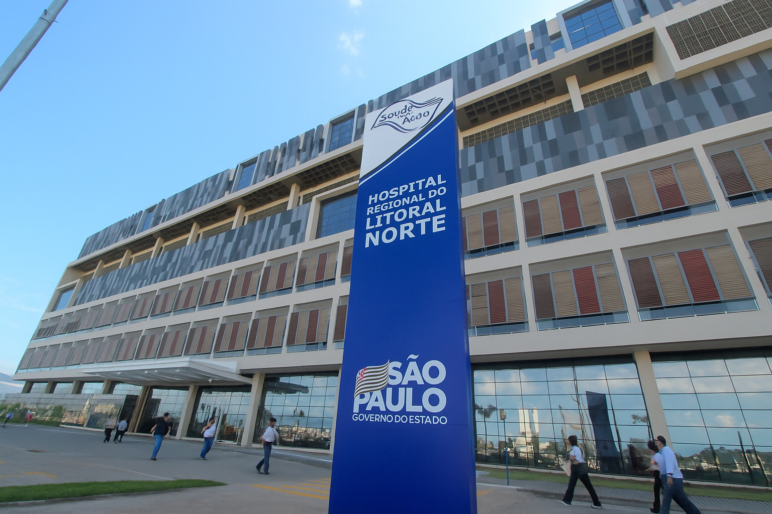 Fachada do Hospital Regional do Litoral Norte em São Paulo com pessoas caminhando na entrada.