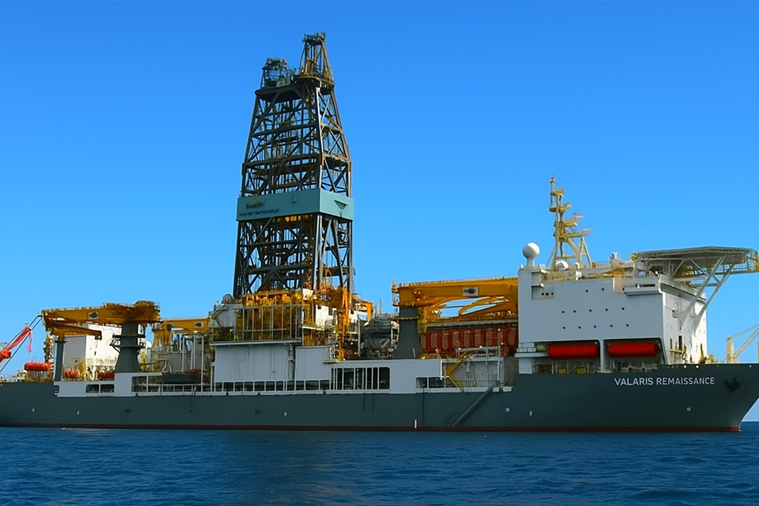 Navio de perfuração offshore Valaris Renaissance navegando em mar calmo sob céu azul limpo com poucas nuvens.