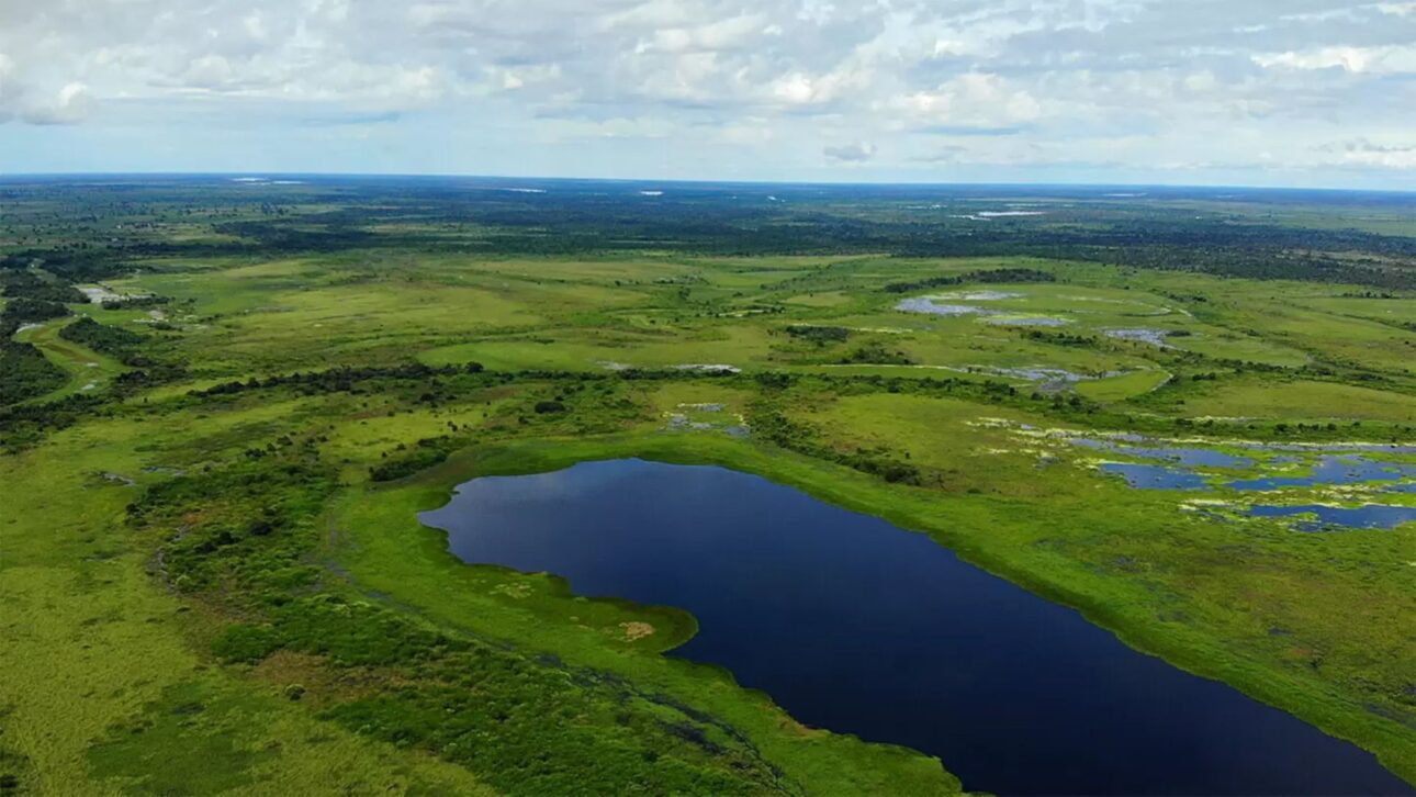Vista aérea da sede da fazenda com reservatório visível ao fundo, evidenciando a infraestrutura robusta e amplos corpos d’água para uso agrícola e pecuário.