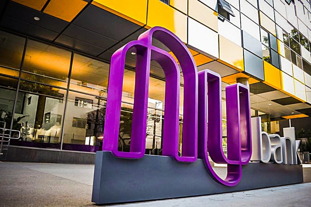 Fachada do prédio do Nubank com logotipo roxo em 3D em frente ao edifício espelhado