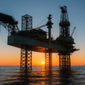 Plataforma de petróleo offshore ao pôr do sol representando a volatilidade e os fluxos globais de energia