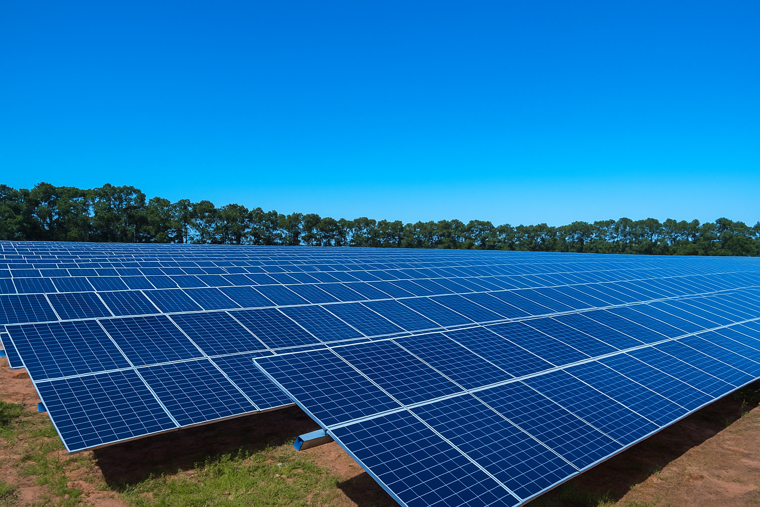Painel solar em grande usina de energia renovável sob céu limpo e azul.
