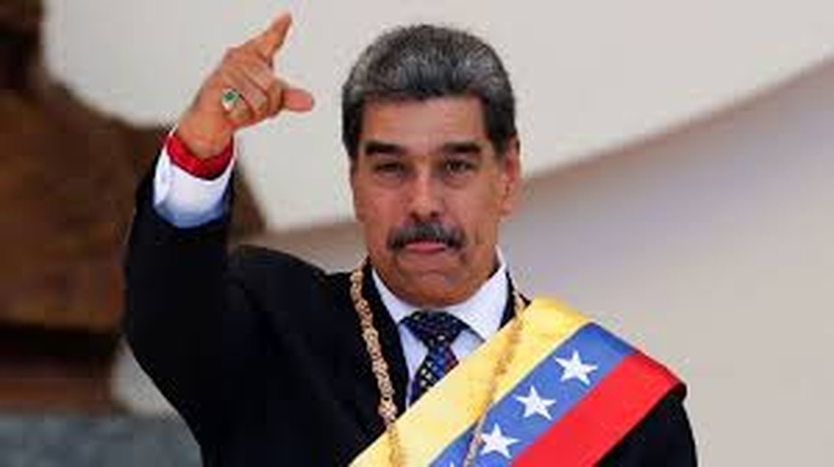 Nicolás Maduro com faixa presidencial da Venezuela, fazendo gesto com a mão direita levantada