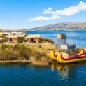 Lago Titicaca com ilhas flutuantes e barcos de totora nas águas azuis entre Peru e Bolívia.