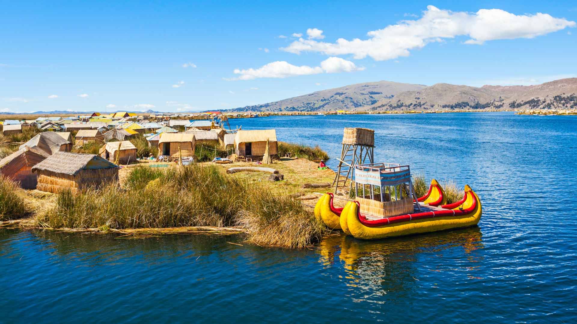 Lago Titicaca com ilhas flutuantes e barcos de totora nas águas azuis entre Peru e Bolívia.