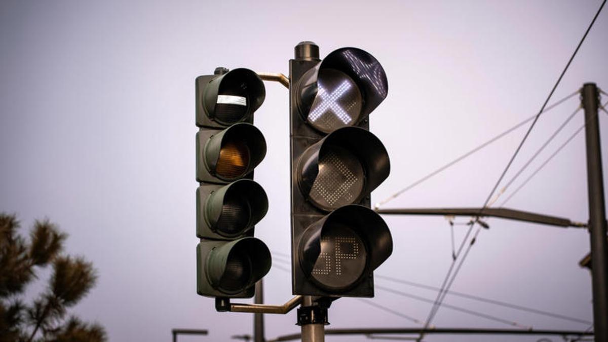 Semáforo moderno com luz branca em destaque simbolizando o futuro dos carros autônomos e do trânsito inteligente nas cidades.