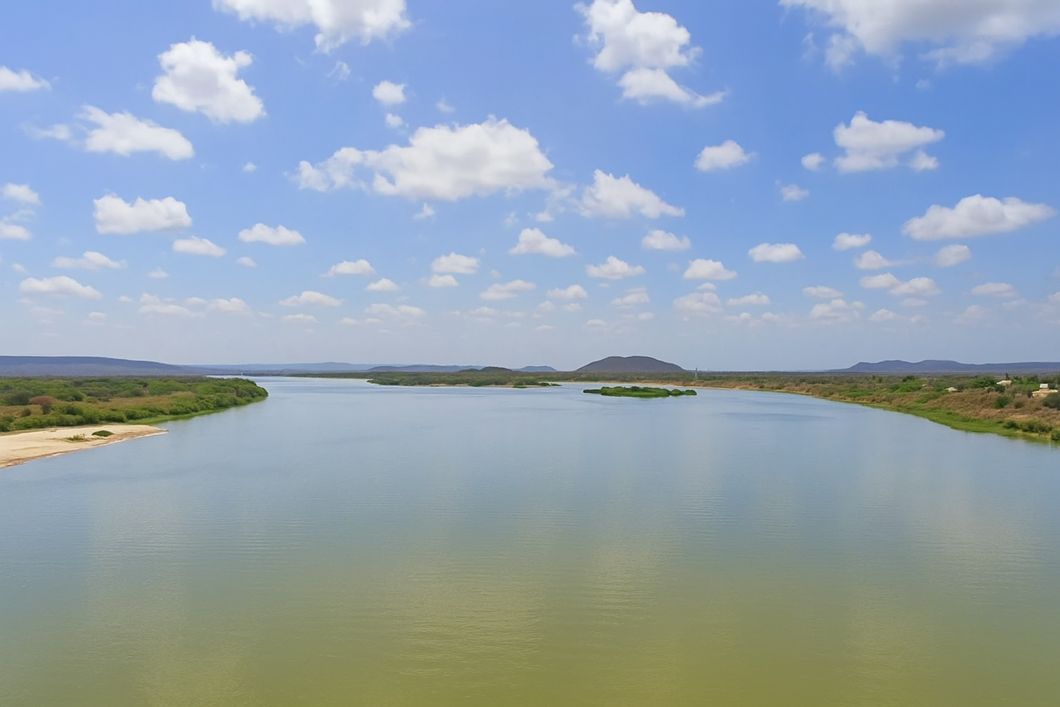 Vista panorâmica de um parque eólico sob um céu azul com nuvens suaves.