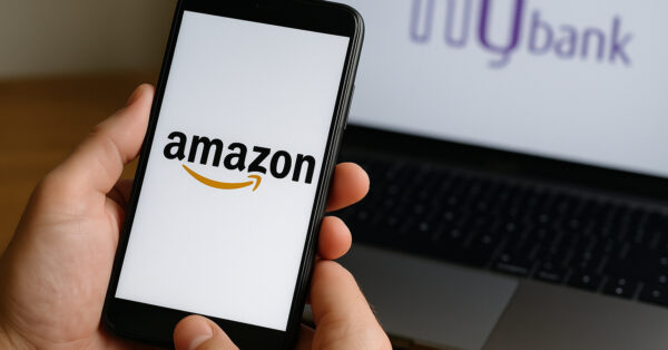 Smartphone exibindo o logotipo da Amazon ao lado de um notebook com o logotipo do Nubank, simbolizando a integração do NuPay ao e-commerce brasileiro.