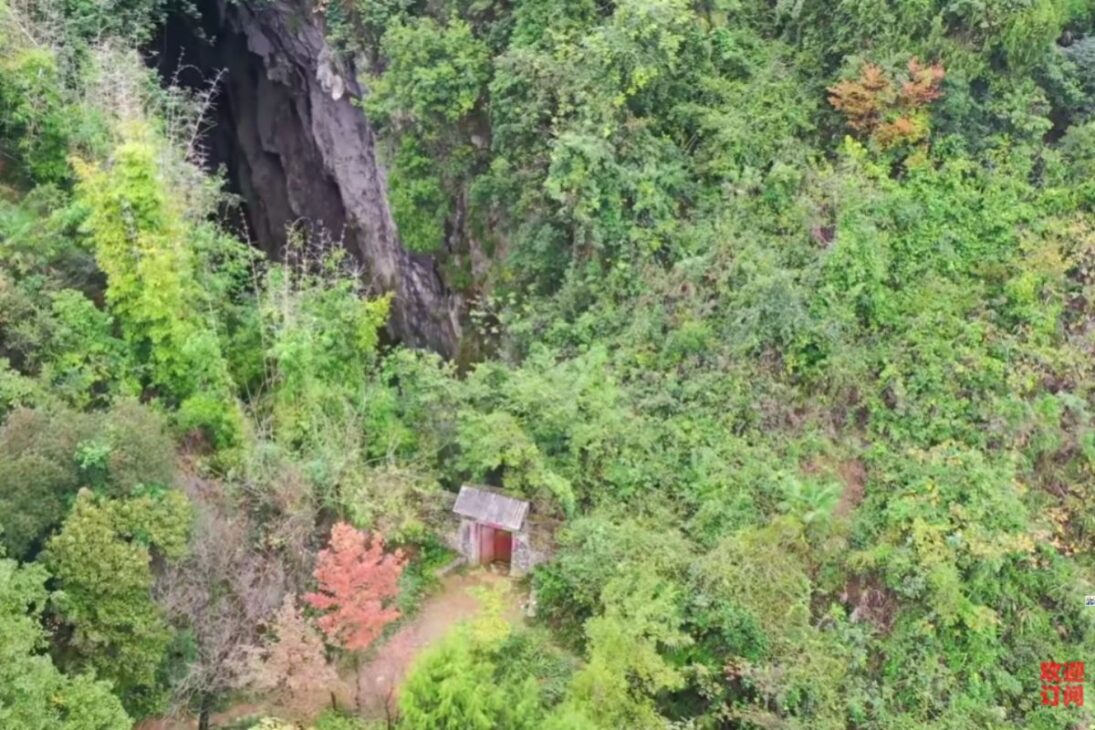 Uma porta antiga escondida nas montanhas revela um buraco gigante e um templo esquecido, com vestígios humanos e estátuas misteriosas sob um penhasco milenar em Chongqing