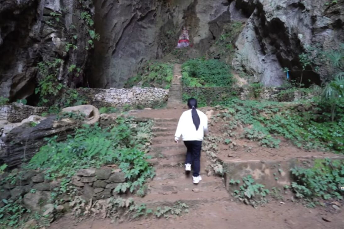 Uma porta antiga escondida nas montanhas revela um buraco gigante e um templo esquecido, com vestígios humanos e estátuas misteriosas sob um penhasco milenar em Chongqing