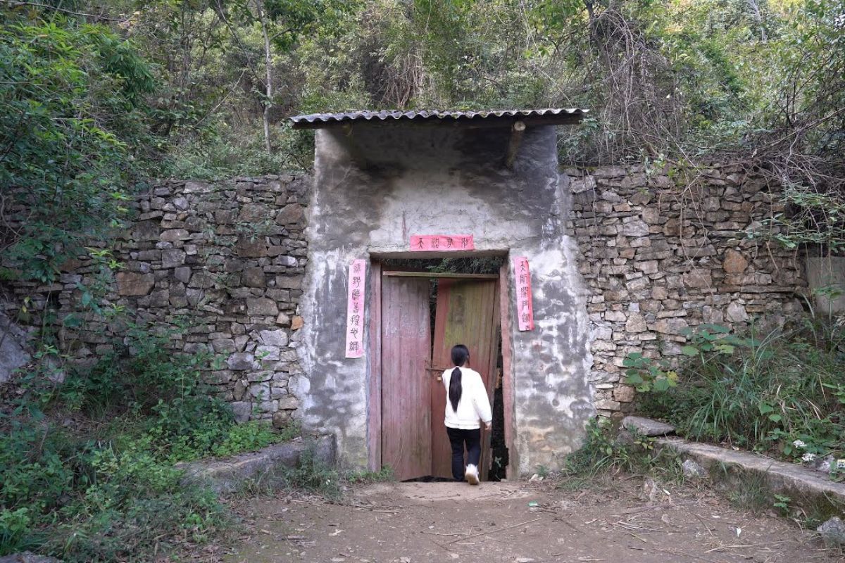Uma porta antiga sob um penhasco milenar em Chongqing revela um buraco gigante que esconde um templo esquecido, vestígios humanos e formações de um sumidouro cárstico único, onde fé e geologia se encontram nas profundezas da montanha.