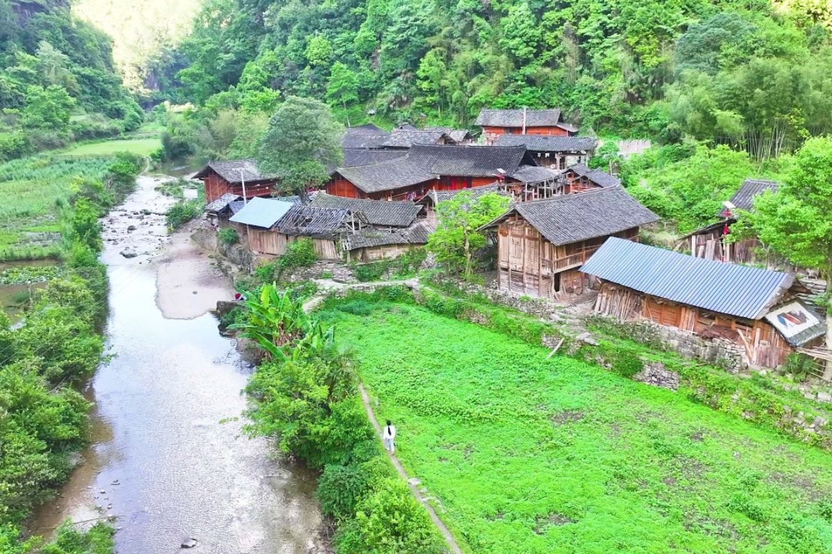vila escondida na China em Guizhou fica dentro de um tiankeng, acessada por penhasco sem estrada, com cavalos no transporte e rotina rural preservada.