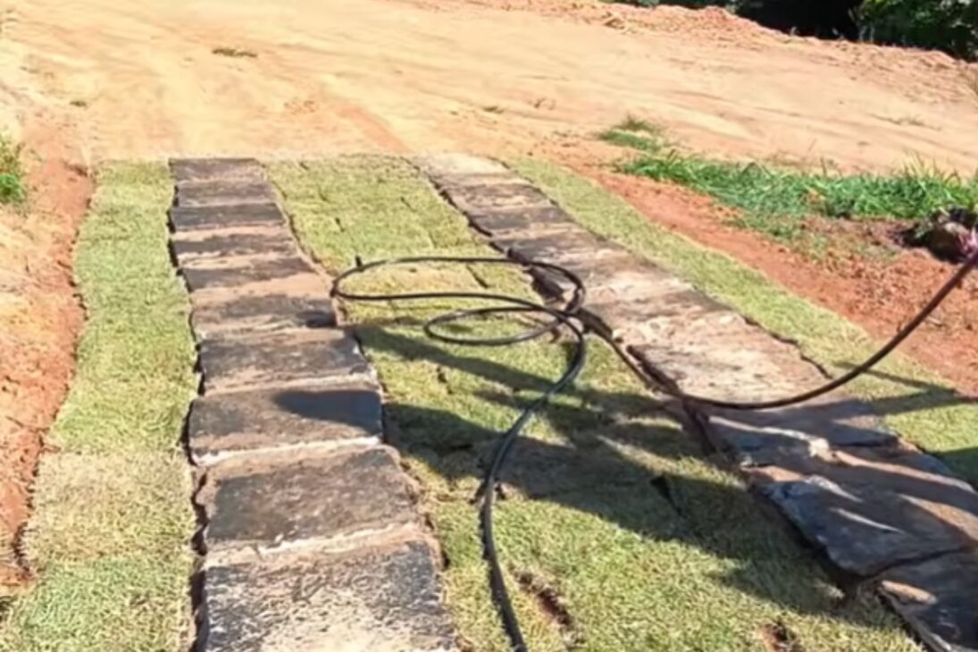 Casal usa caminho de pedras, grama e irrigação com controle pelo celular para renovar a entrada do sítio.