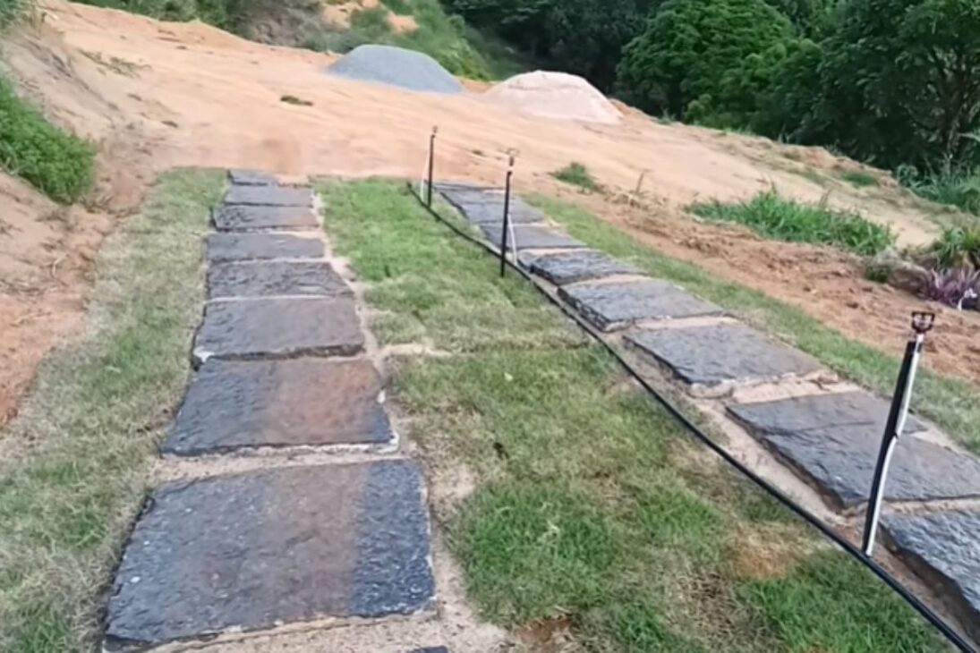 Casal usa caminho de pedras, grama e irrigação com controle pelo celular para renovar a entrada do sítio.