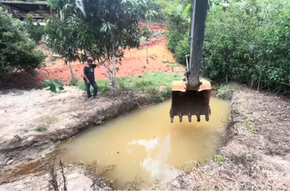 Operador com escavadeira adapta caixa seca, controla enxurrada e cria tanque de peixe em obra com lama e pouco espaço.