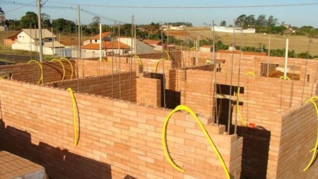 Tijolo de encaixe feito com até 90% de solo reduz custos, dispensa argamassa e atende normas com resistência acima de 2 MPa.