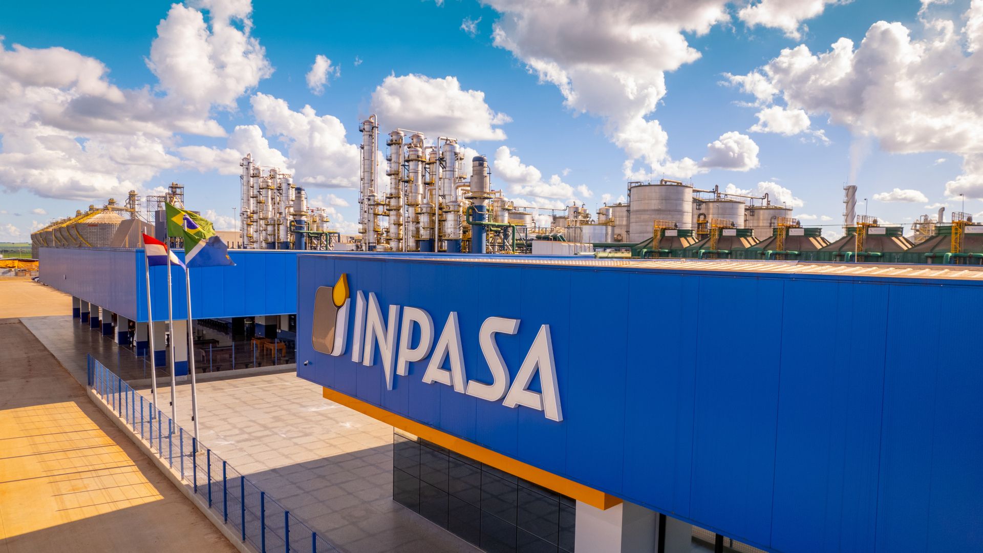 Fábrica da Inpasa com estrutura industrial moderna e silos de armazenamento, destacando produção de etanol de milho e biocombustíveis sustentáveis no Brasil