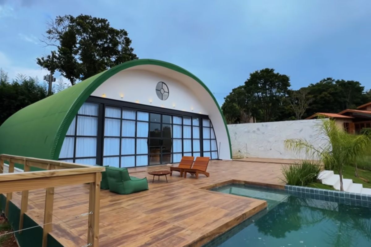 Uma arquiteta transformou um hangar em casa curva com vista para a represa estrutura metálica montada em uma semana, portas de vidro, cores ousadas, tucanos no lavabo (2)