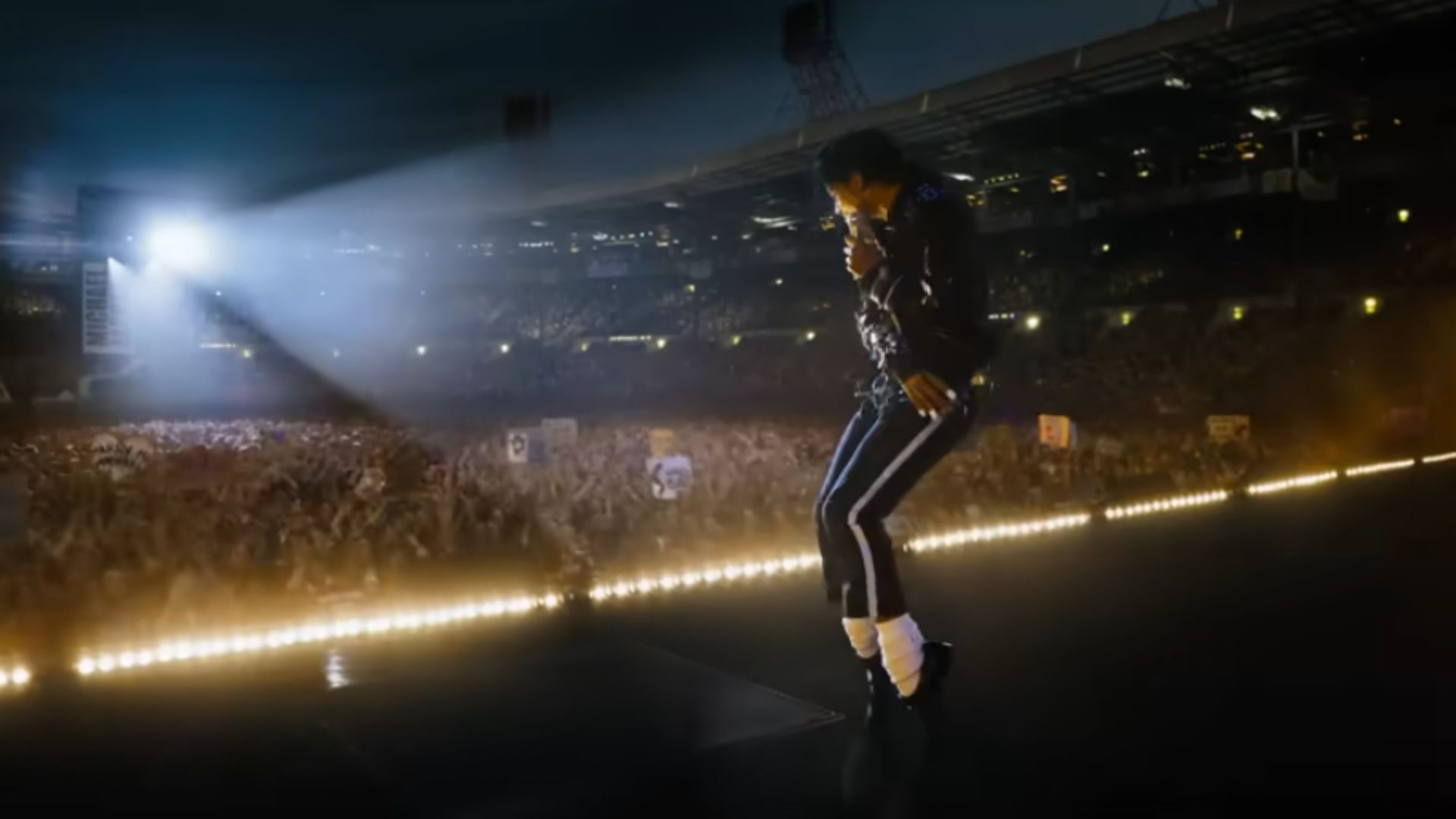 cantor estilo Michael Jackson performando no palco com luzes e público ao fundo