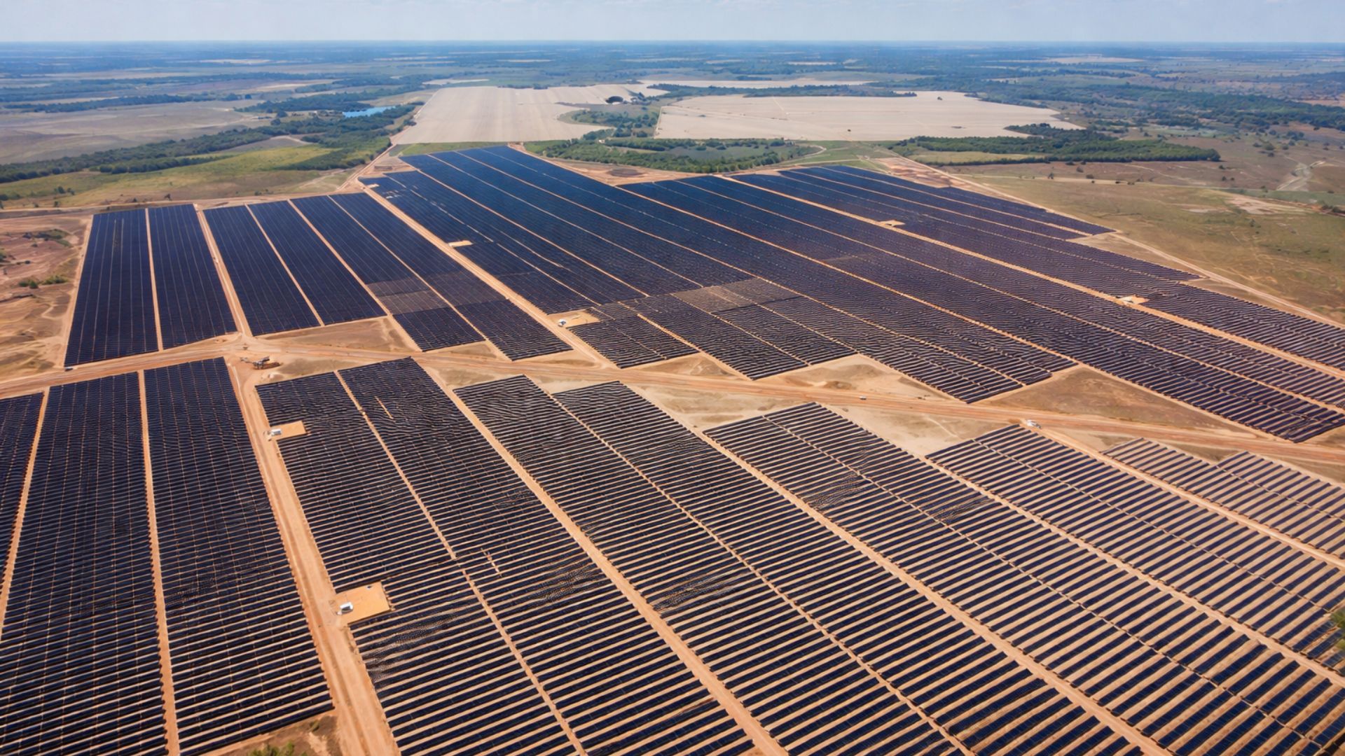 Vista aérea de um complexo solar em Barro Alto, Goiás, com milhares de painéis de energia solar organizados em fileiras, destacando a expansão da energia renovável no Brasil.