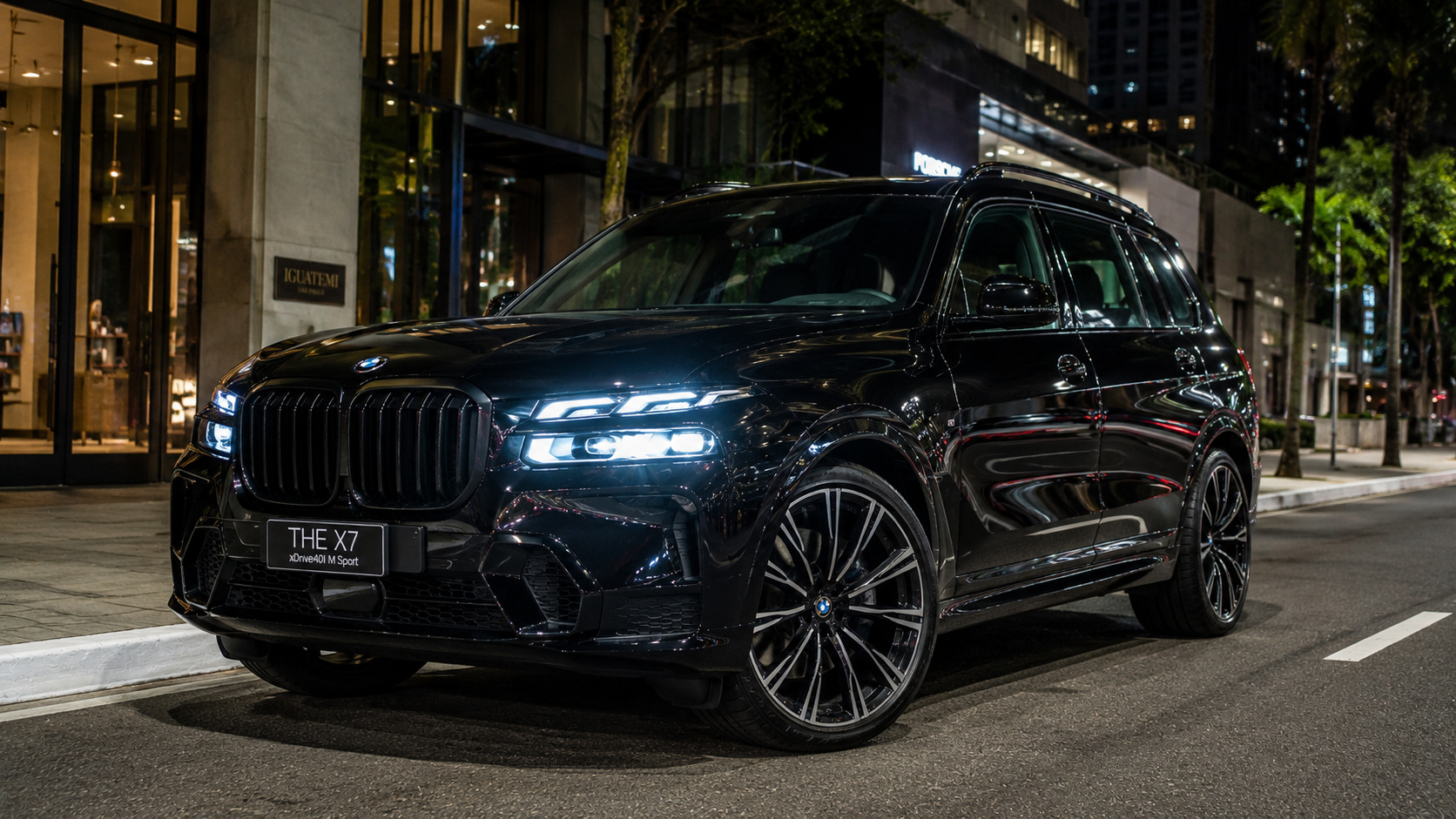 BMW X7 preto estacionado em avenida de São Paulo com iluminação noturna e visual de SUV de luxo.