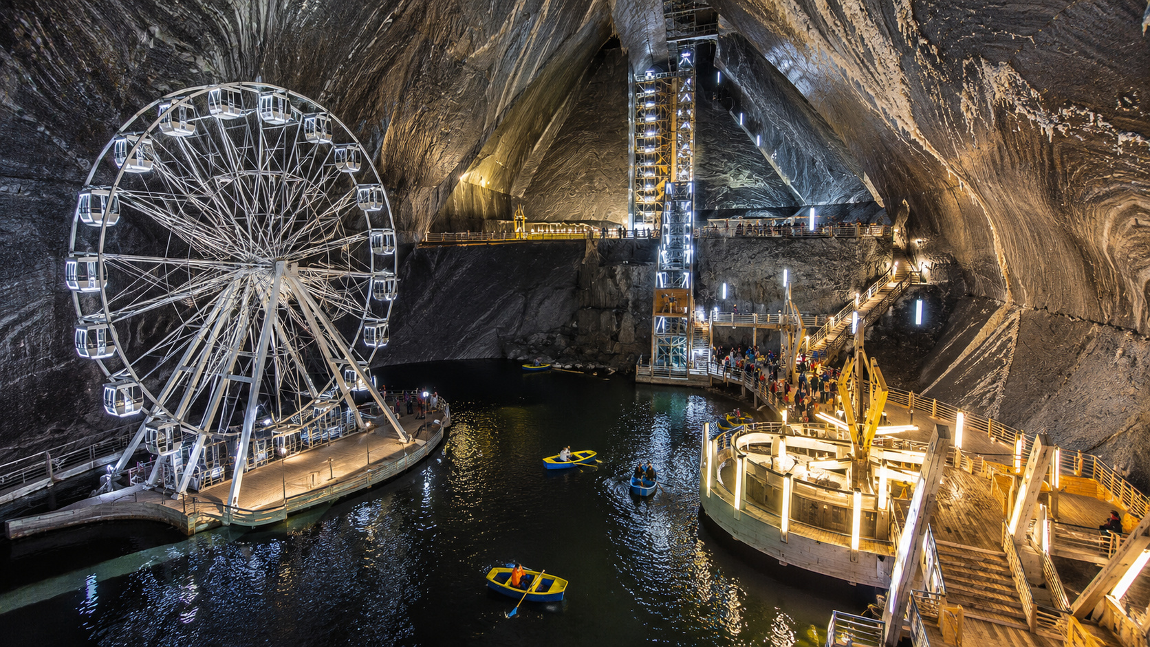 na Romênia uma antiga mina de sal se transforma em atração subterrânea com roda gigante, lago interno e passarelas dentro de câmaras gigantes abertas pela mineração