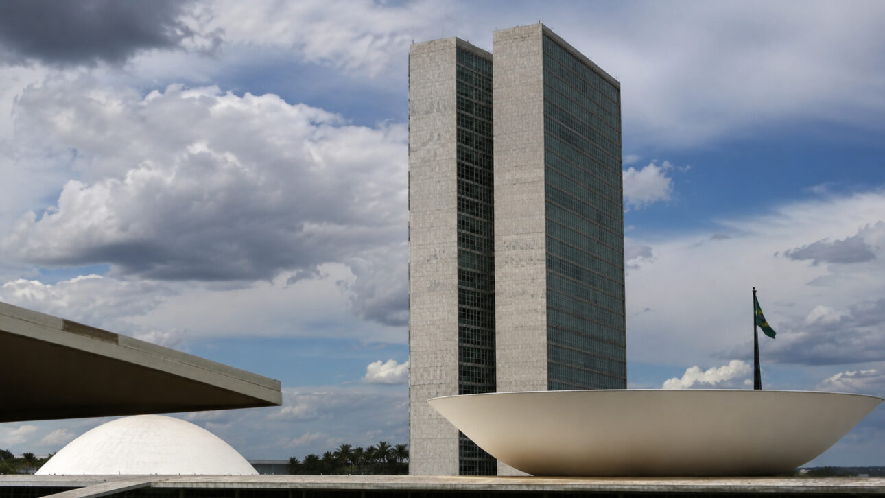 View of the National Congress in Brasília, with the Legislative towers in the background and modern architectural structures in the foreground, representing the debate on the PEC that expands tax immunity for churches and its possible impacts on public revenue and education funding.