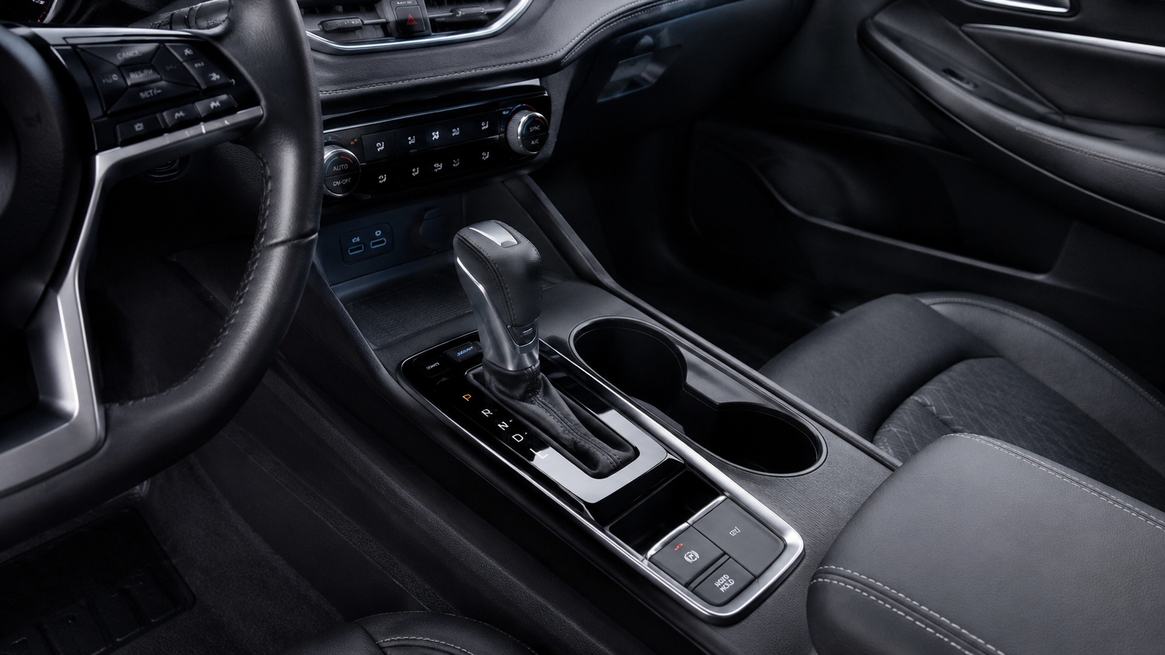 Interior de carro com câmbio automático em destaque, mostrando a alavanca de transmissão e o console central, ilustrando a função da marcha baixa “L” para maior controle em subidas e descidas.