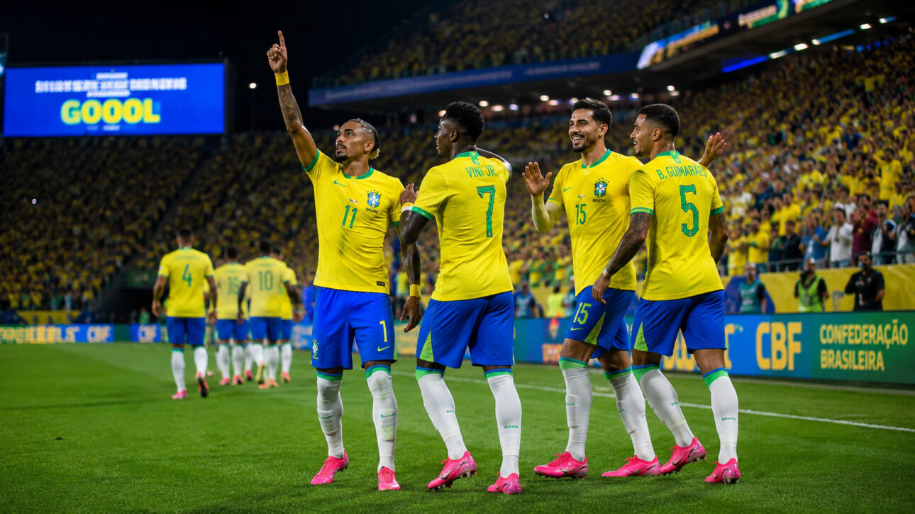 Jogadores de futebol celebram uma jogada em estádio lotado enquanto usam chuteiras rosas, destaque visual que se tornou tendência durante a Copa do Mundo de 2026.