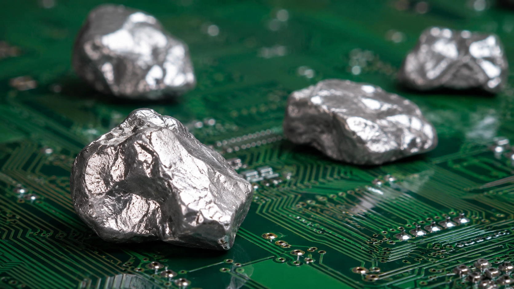 Fragmentos metálicos sobre placa de circuito representam os minerais críticos e terras raras no centro da disputa entre Brasil e G7