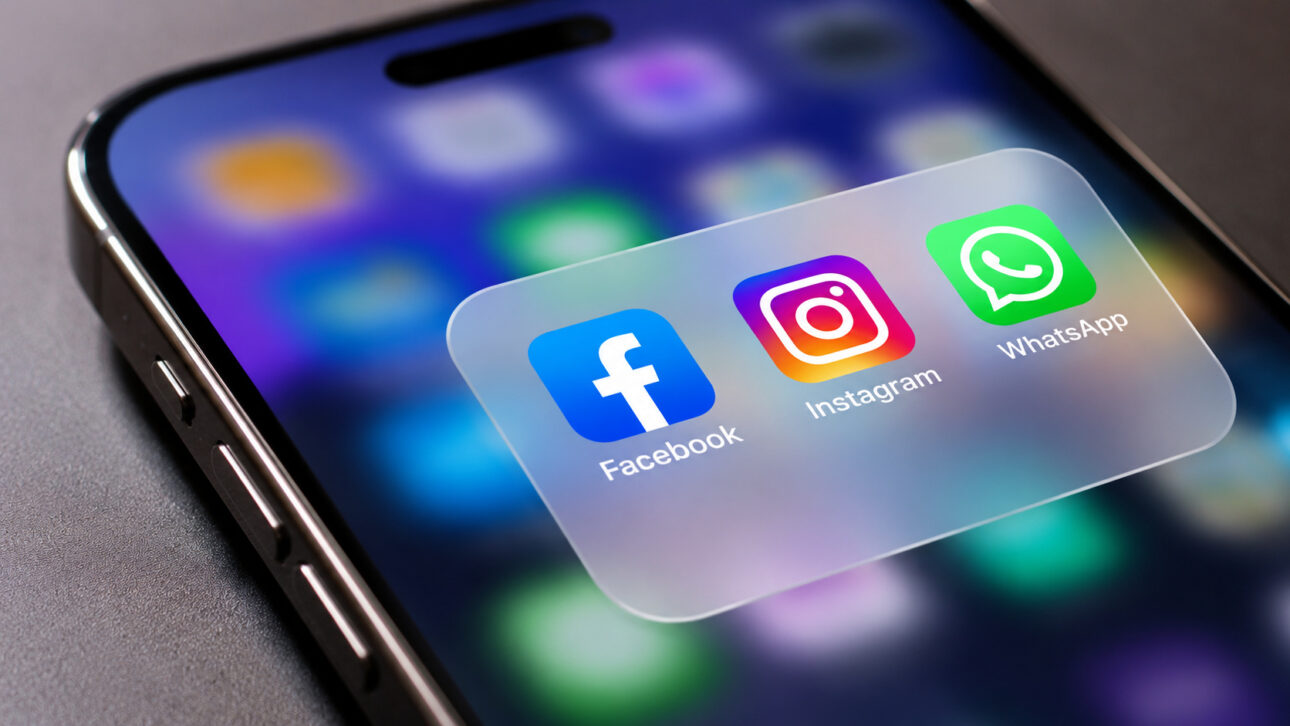 Smartphone in close-up with icons of Facebook, Instagram, and WhatsApp, representing communication and social media apps on a digital screen.