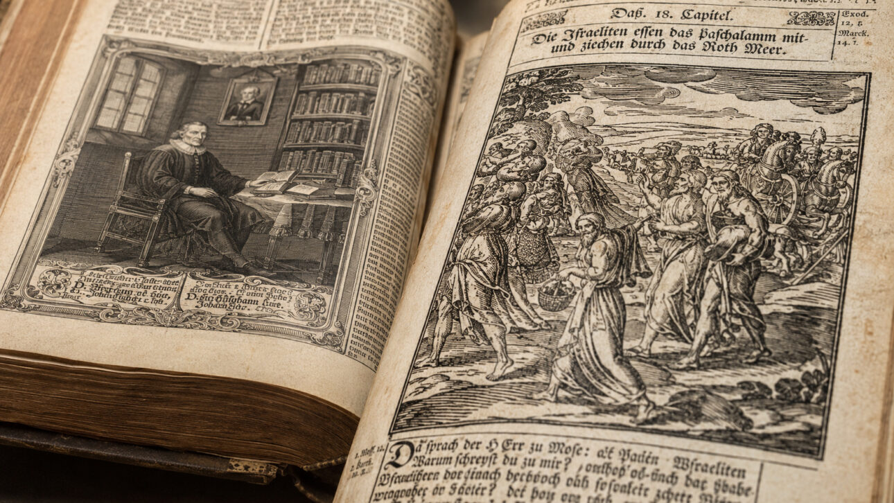 Old Lutheran Bible open with a portrait of a scholar, texts in German, and biblical engraving on aged pages.