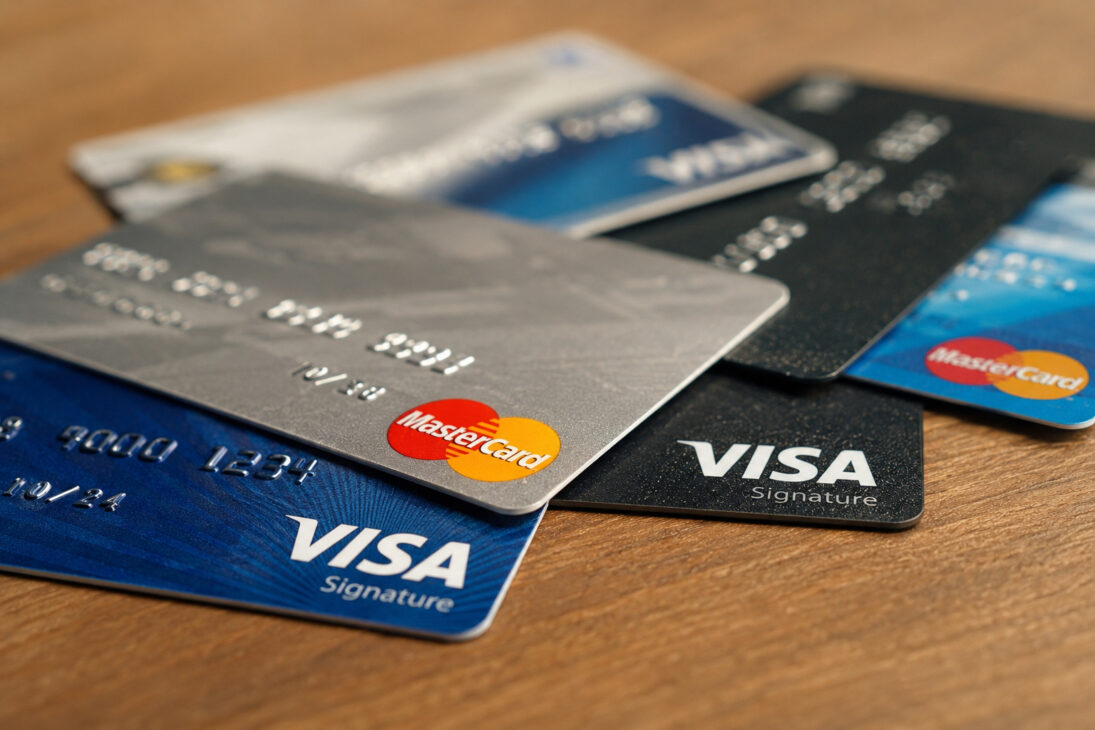 Visa and Mastercard cards overlaid on a wooden surface, illustrating the impact of the suspension of international payments in Cuba after new US sanctions.