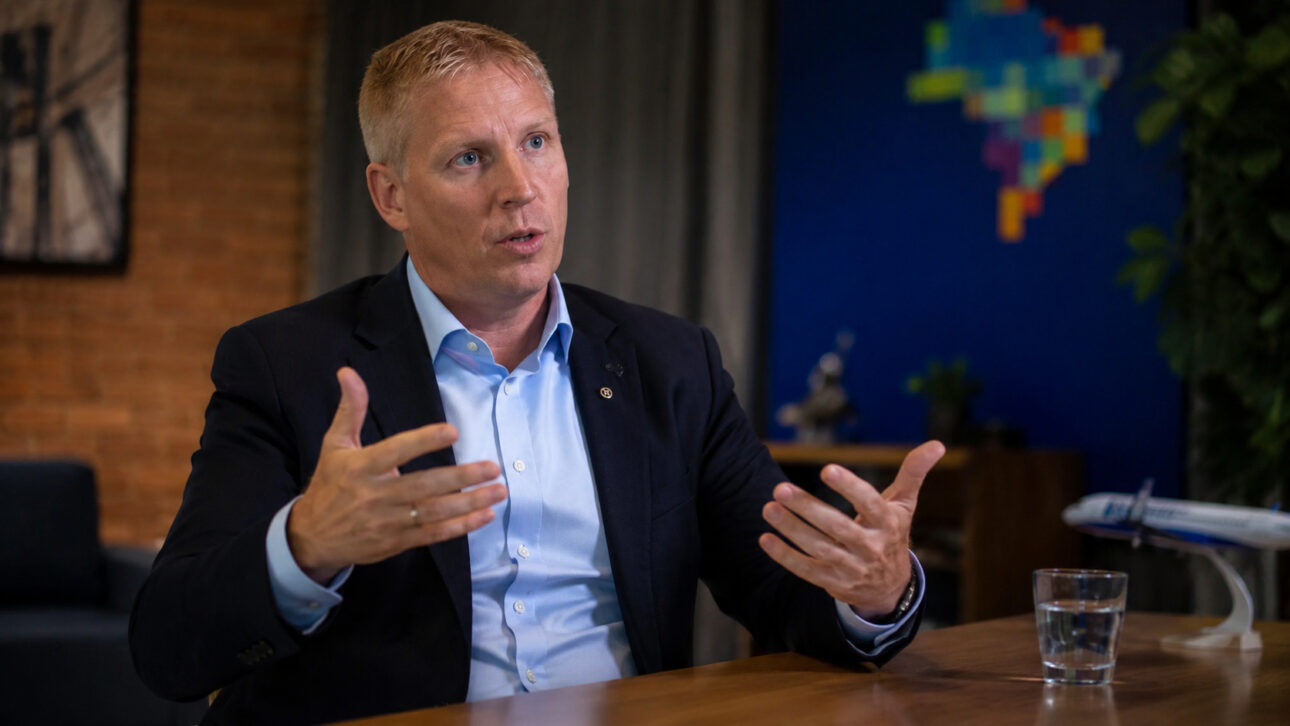 Azul executive during an interview in a corporate environment, talking about the company's strategies in light of the increase in aviation kerosene costs and the need to reduce flight frequencies.