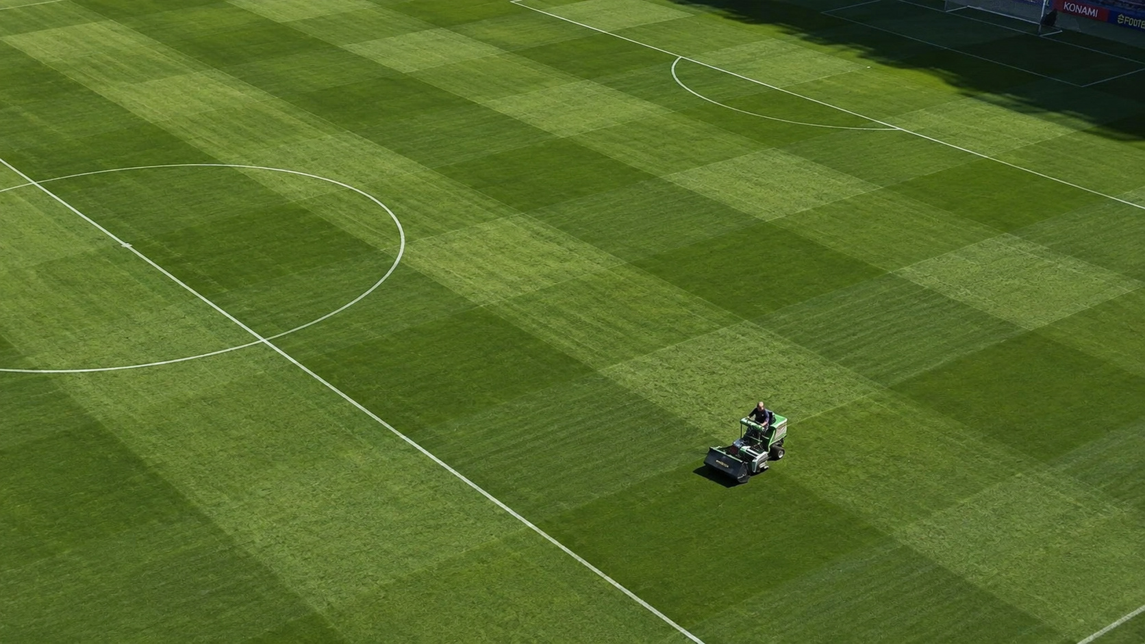Máquina realiza manutenção em gramado de estádio de futebol com padrão profissional, destacando a tecnologia e os cuidados adotados para preparar os campos da Copa do Mundo de 2026.