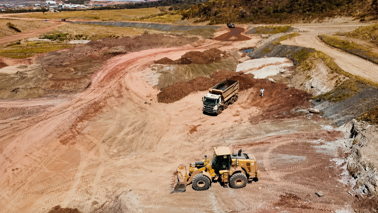 Aerial view of mining area with truck, loader, and excavated soil on a rural property in Goiás explored for rare earth extraction.