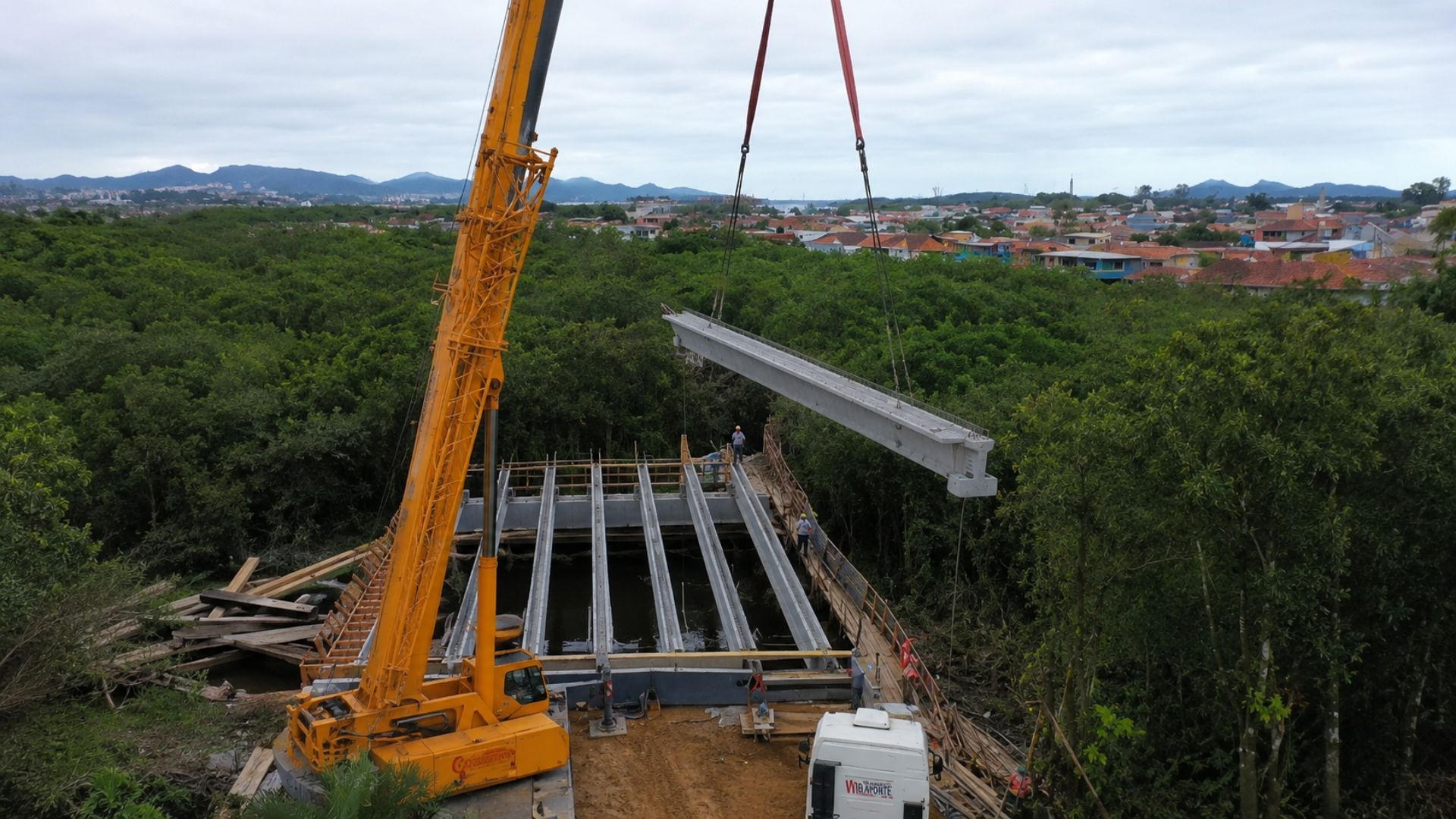 A ponte da Anêmonas, em Joinville, recebe vigas içadas por guindaste de 50 m e vai mudar o trânsito entre dois bairros; obra soma R$ 44 milhões e abre em 2027.