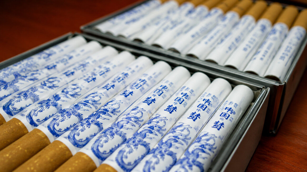 Maços de cigarros organizados em bandejas de exposição, representando a indústria do tabaco na China e a discussão sobre aumento de impostos para reduzir os impactos do tabagismo na saúde pública.