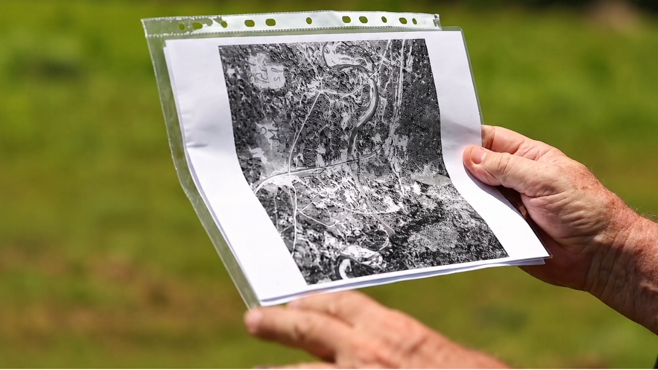 Pesquisadores analisam imagens aéreas antigas e mapas da época da Segunda Guerra para localizar vestígios da estação Nithe, que reapareceu temporariamente após mais de 40 anos sob a água e pode voltar a desaparecer com a elevação do reservatório.