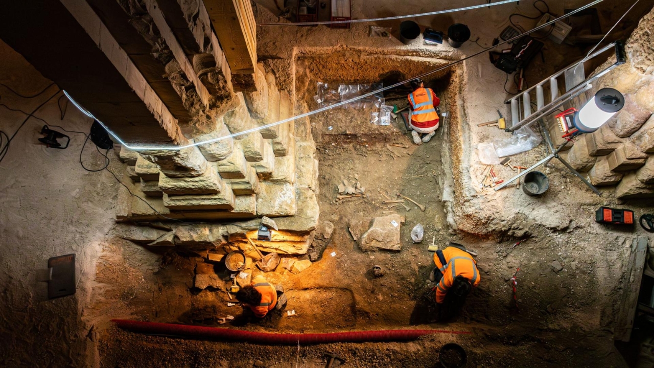 La escalera oculta y los restos mortales alrededor: escena de la excavación del INRAP en el transepto de la Iglesia de Saint-Philibert, Dijon, Francia, en 2024 — Crédito: Christophe Fouquin / INRAP