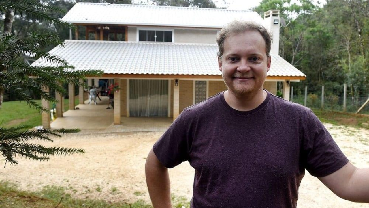 Diante do sobrado de dois pavimentos em Almirante Tamandaré, o analista de sistemas simboliza a virada de uma obra que começou travada por orçamentos altos e acabou se tornando uma casa de 200 m² construída ao longo de três anos, com tutoriais online, tijolo ecológico e economia estimada em cerca de R$ 150 mil em mão de obra.