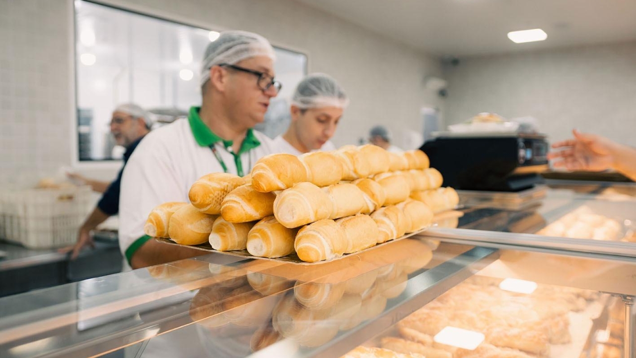 Funcionários organizam pães em balcão de padaria, setor que já abriu 26,4 mil pequenos negócios em apenas parte de 2025 no Brasil e avança em ritmo de uma nova padaria a cada seis minutos, segundo dados do Sebrae.
